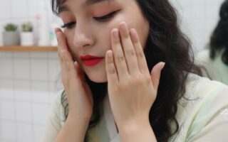 Woman applying skincare on face during Korean glass skin night routine