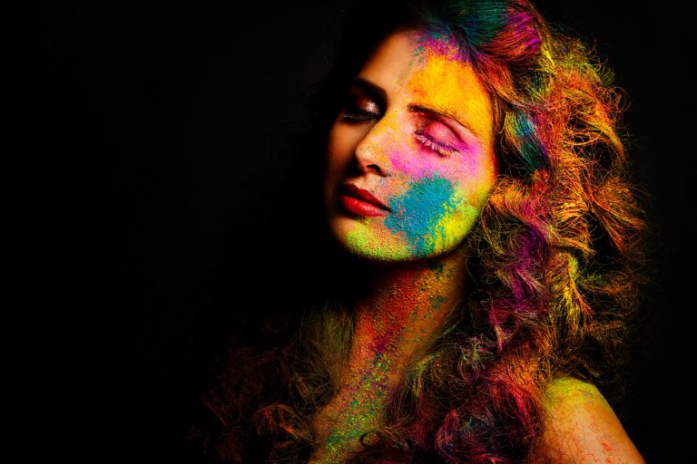 A striking portrait of a woman with vibrant colored powders on her face, epitomizing the Holi festival's spirit.