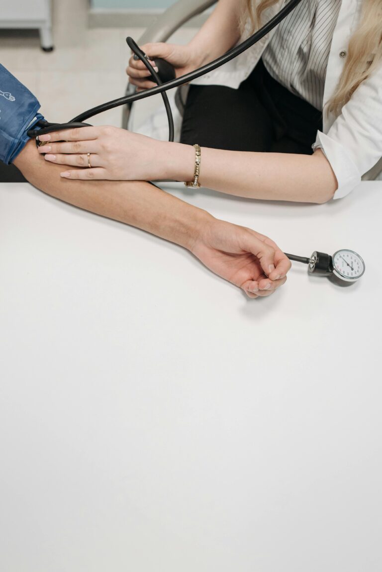 A medical practitioner checking a patient's blood pressure in a clinical setting.